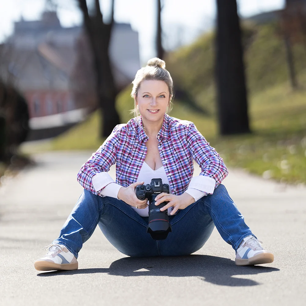 Nadja Sperner auf dem Boden mit der Kamera in der Hand.